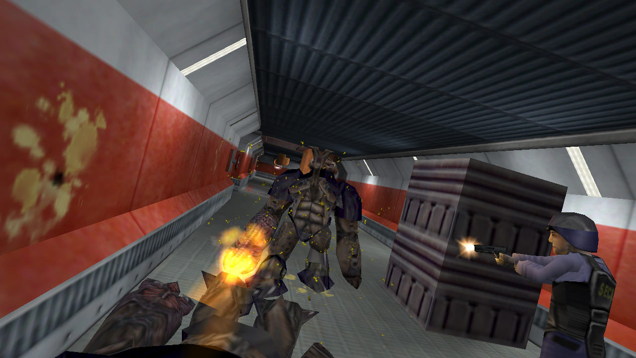 Screenshot of Gordon Freeman facing an Alien Grunt while a security guard shoots at it in a narrow corridor.