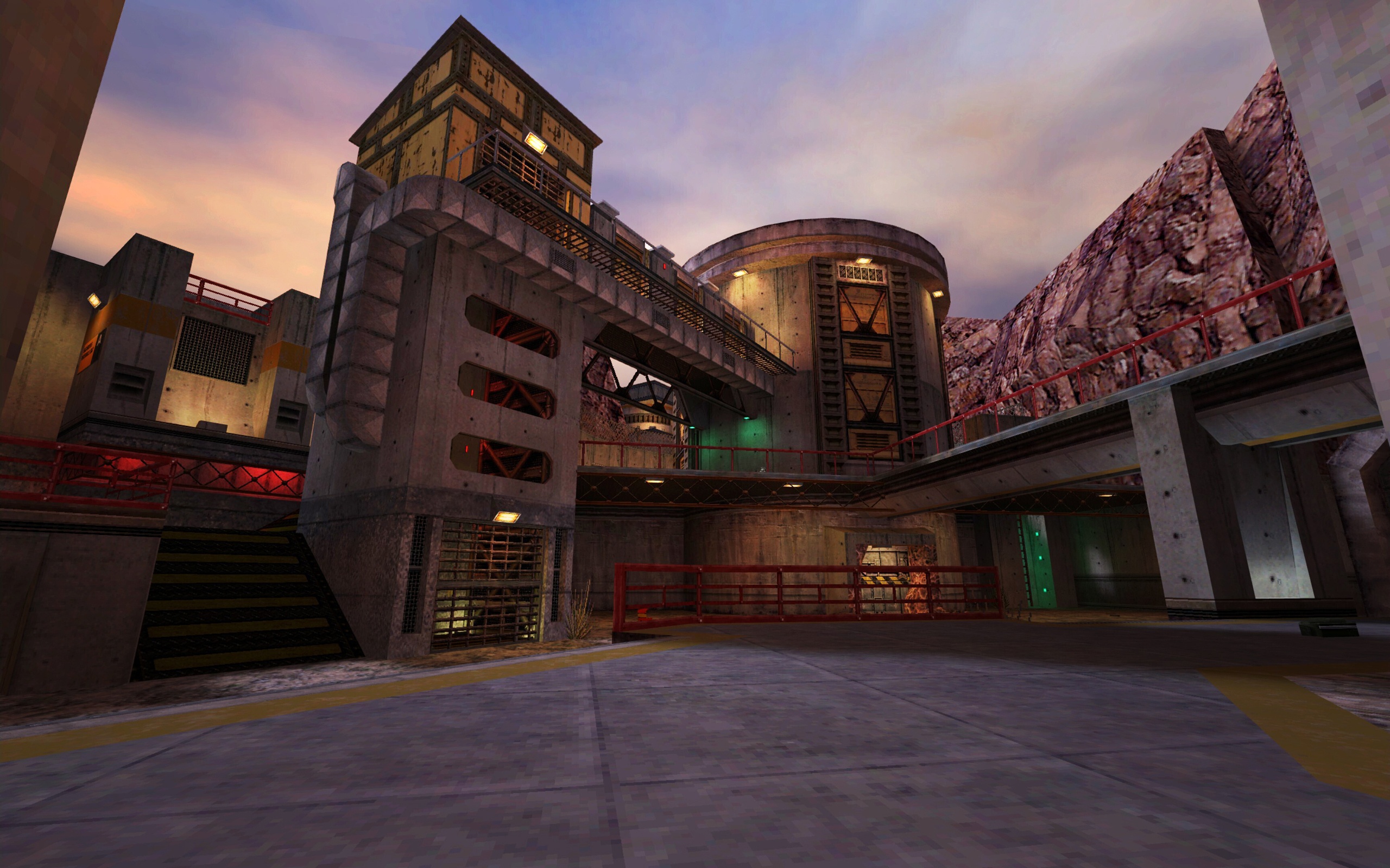 Screenshot of the Black Mesa exterior with industrial buildings, walkways, and rocky cliffs at sunset.